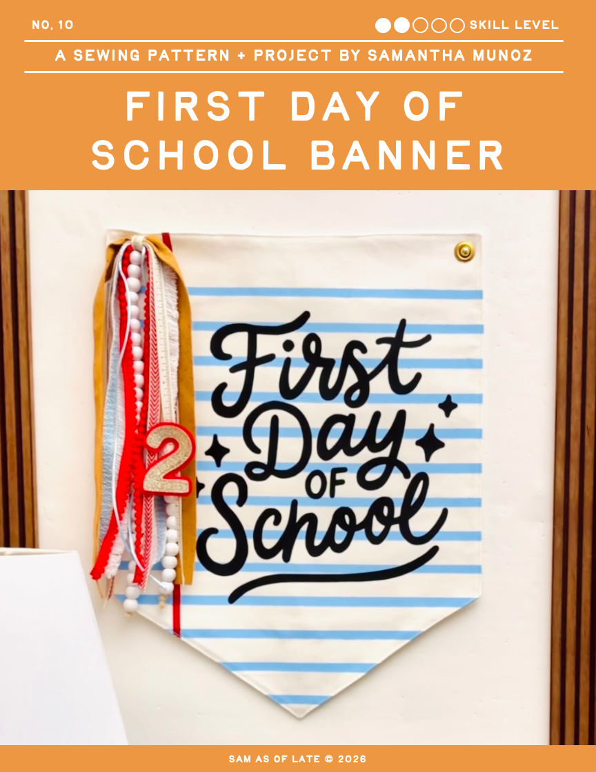 Sewing pattern cover for 'First Day of School Banner' by Samantha Munoz, showing a striped fabric banner with 'First Day of School' in black script and a wooden number 2.